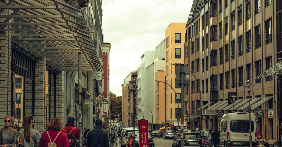 Busy city street with pedestrians and low buildings in warm afternoon light